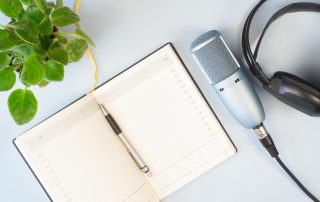Notizbuch und Podcastmikrofon.