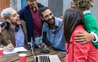 Eine Gruppe von fünf Personen nimmt gemeinsam einen Podcast auf.